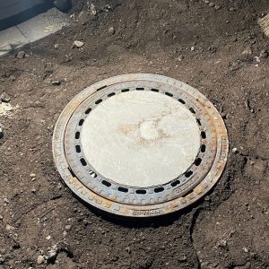 Abflussdeckel vor der Rohrinspektion geöffnet